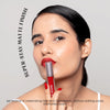 Female model applying Dawn To Dawn Super Stay Liquid Matte Lipstick - Red Lava